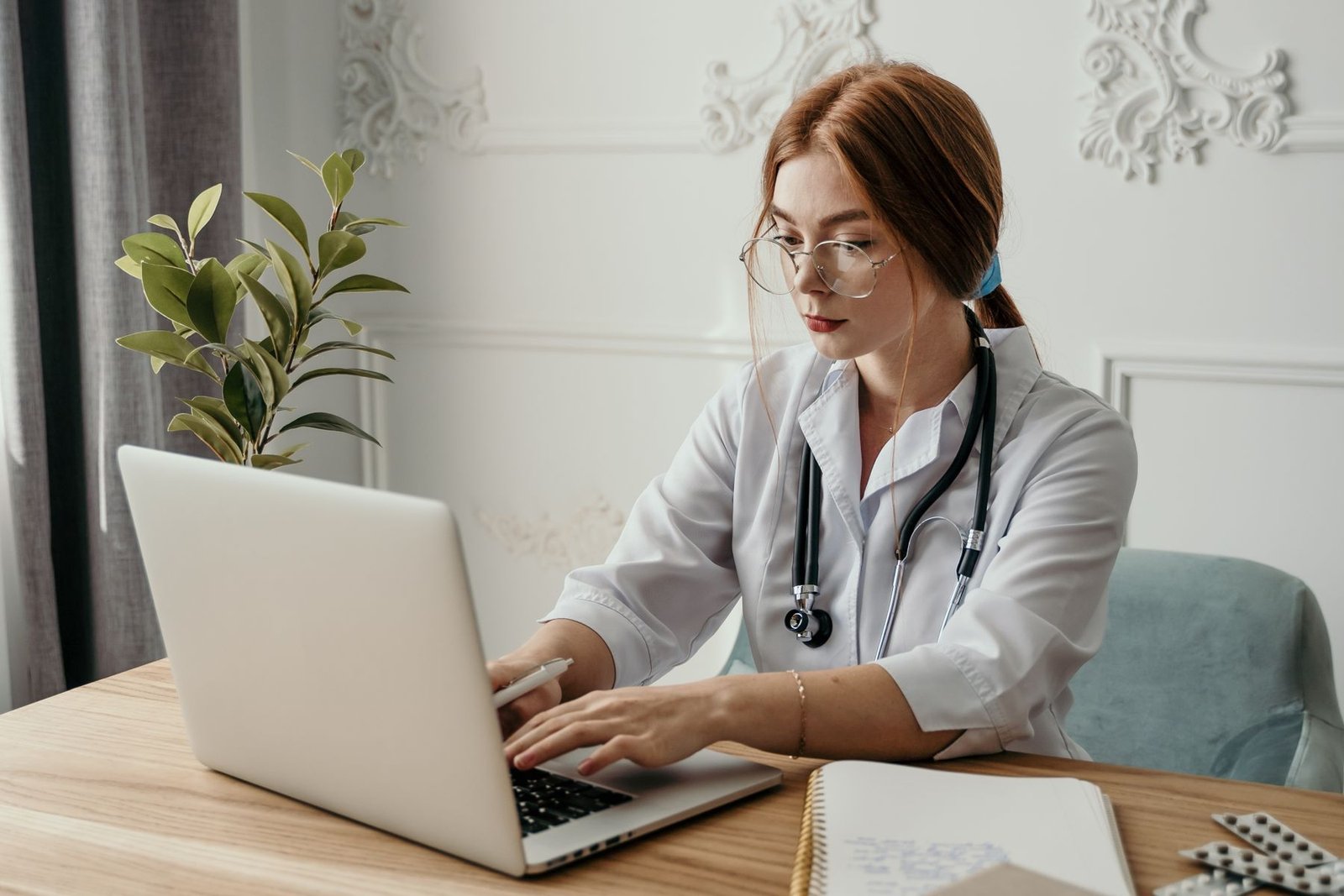 Healthcare professional completing administrative work on a laptop