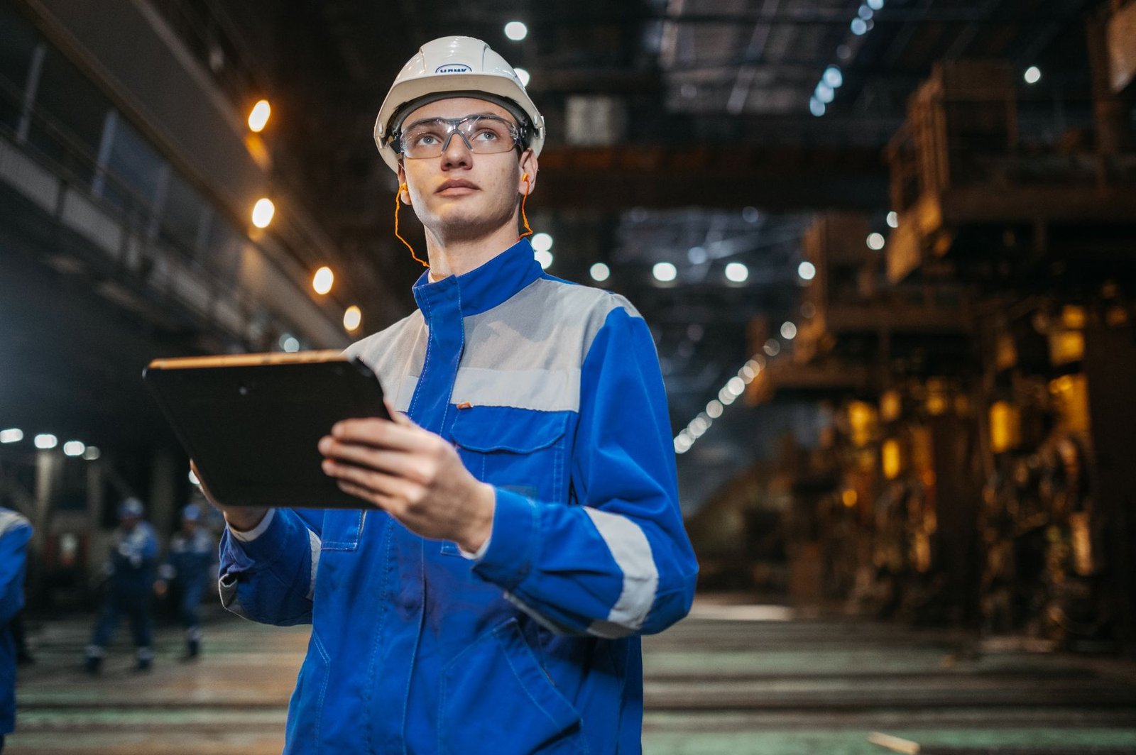 Manufacturing operations professional using a tablet on a factory floor