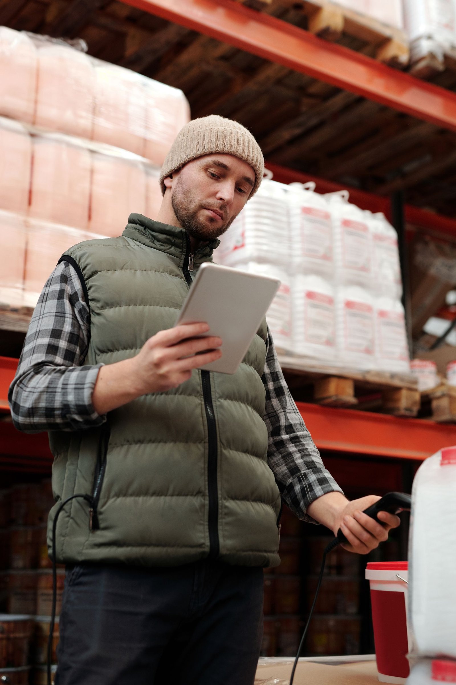 Distribution employee checking warehouse inventory with a tablet